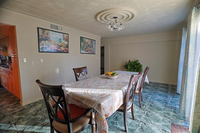 dining space featuring a notable chandelier and a textured ceiling