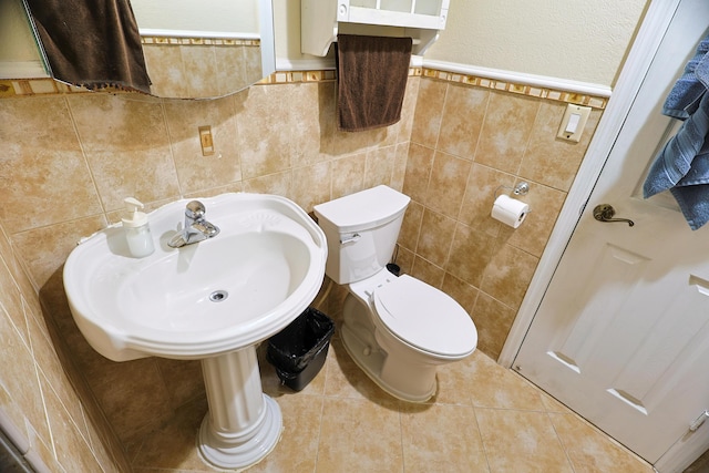 bathroom with tile patterned flooring, tile walls, and toilet