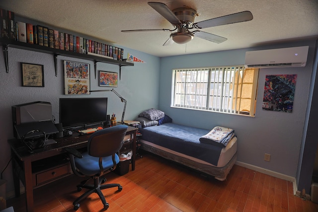 bedroom with hardwood / wood-style flooring, ceiling fan, a textured ceiling, and a wall mounted AC