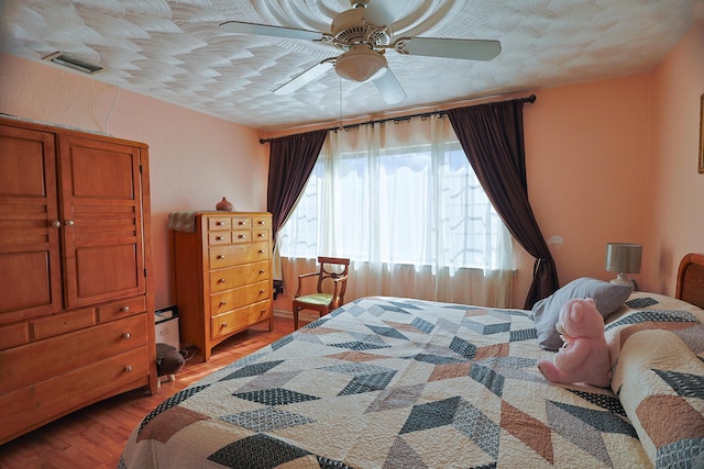 bedroom with ceiling fan and wood-type flooring