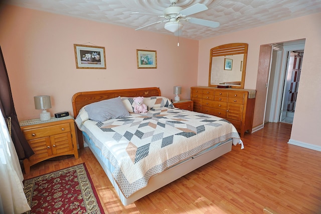 bedroom with ceiling fan, a textured ceiling, and light wood-type flooring