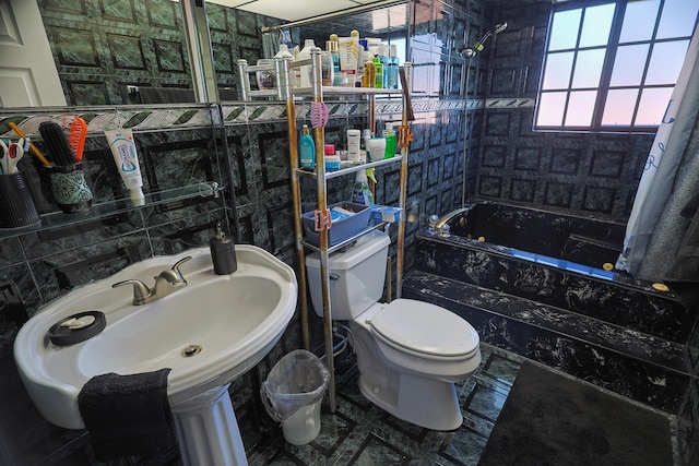 full bathroom featuring tiled shower / bath, toilet, tile walls, and sink