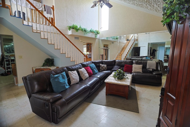 living room with ceiling fan and a high ceiling