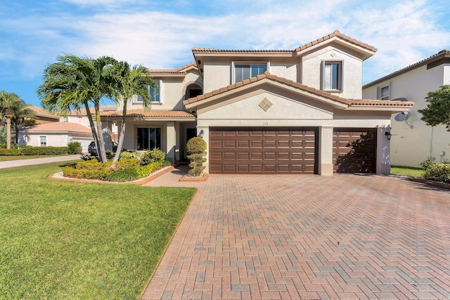 mediterranean / spanish-style home with a garage and a front lawn