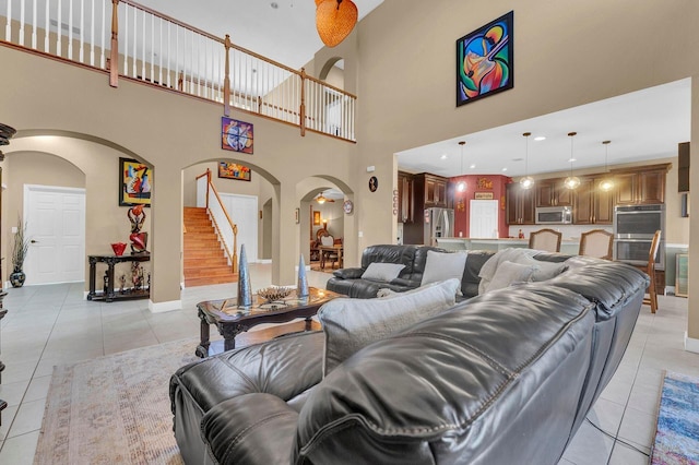 living room featuring a towering ceiling and light tile patterned flooring