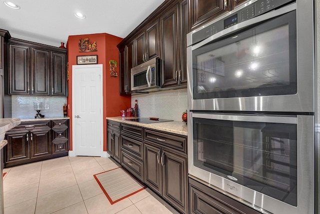 kitchen with decorative backsplash, dark brown cabinetry, stainless steel appliances, and light tile patterned flooring