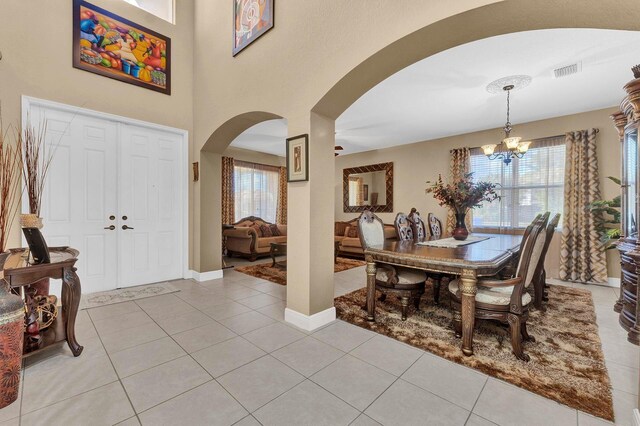 tiled entrance foyer with a chandelier