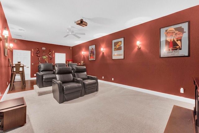 carpeted cinema room with ceiling fan