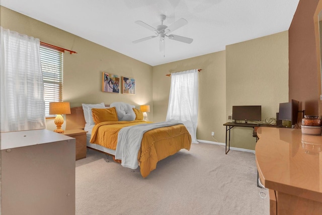 bedroom with light colored carpet, multiple windows, and ceiling fan