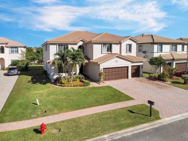 mediterranean / spanish house featuring a front yard and a garage