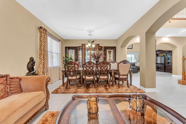 dining area with plenty of natural light, light tile patterned flooring, and an inviting chandelier