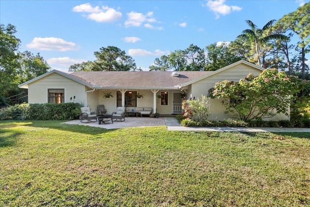 back of property featuring a lawn, outdoor lounge area, and a patio area