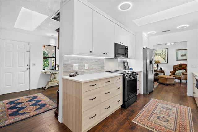 kitchen featuring white cabinets, a skylight, stainless steel fridge, black / electric stove, and dark hardwood / wood-style flooring