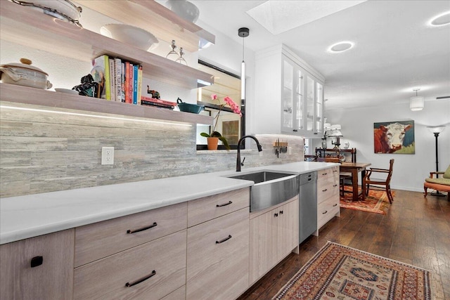 kitchen with sink, dark hardwood / wood-style flooring, stainless steel dishwasher, backsplash, and decorative light fixtures