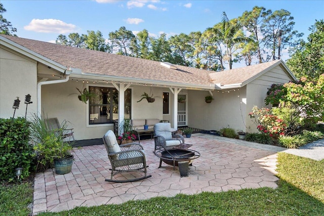 view of patio with an outdoor living space with a fire pit