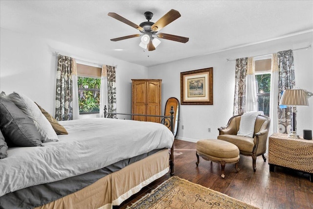 bedroom with multiple windows, ceiling fan, and dark hardwood / wood-style floors