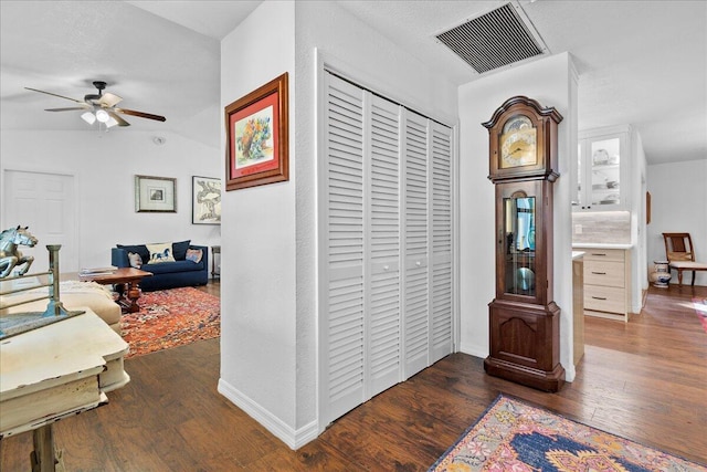 hall with vaulted ceiling and dark hardwood / wood-style floors