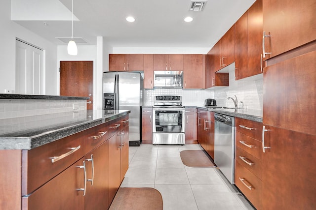 kitchen with sink, decorative backsplash, appliances with stainless steel finishes, decorative light fixtures, and light tile patterned flooring