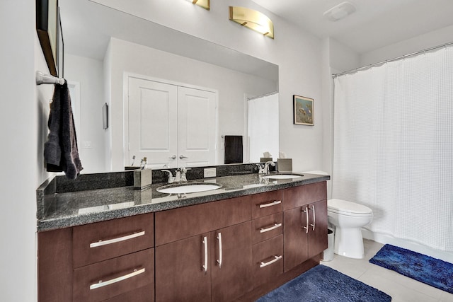 bathroom with tile patterned floors, walk in shower, vanity, and toilet