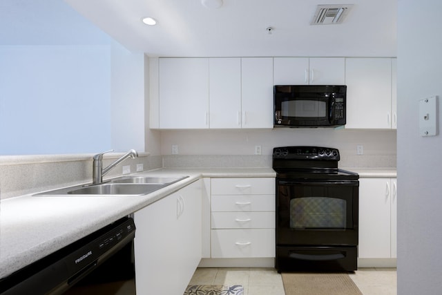 kitchen with white cabinetry, sink, light tile patterned flooring, and black appliances