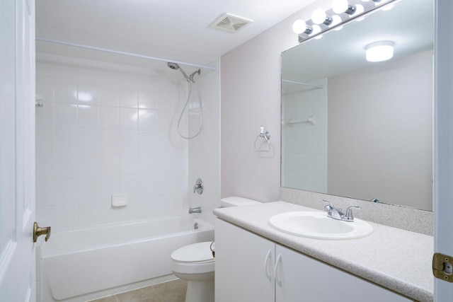 full bathroom with tile patterned flooring, vanity, tiled shower / bath combo, and toilet