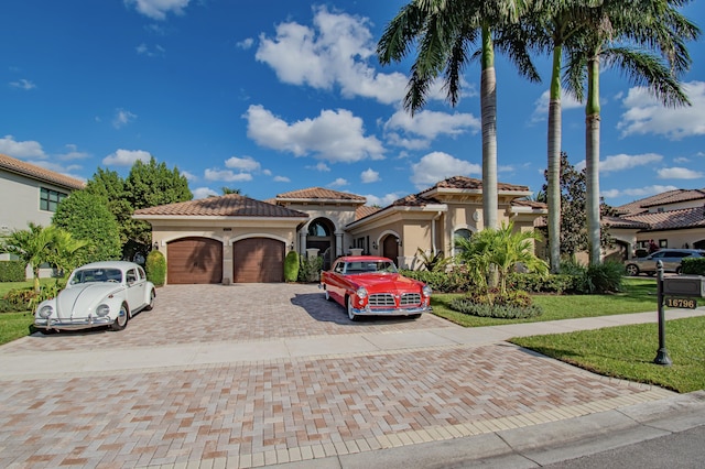 mediterranean / spanish house with a garage and a front yard