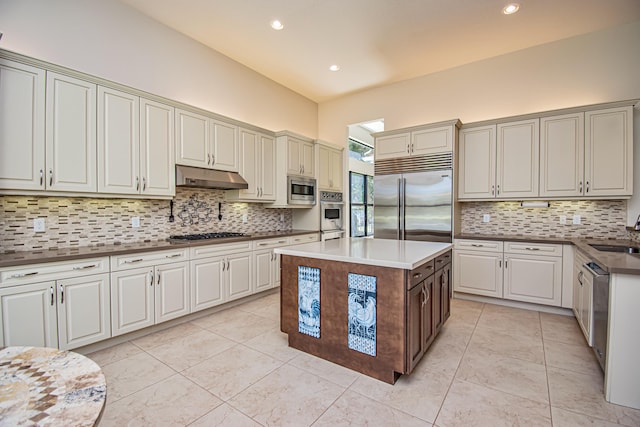 kitchen with sink, light tile patterned floors, backsplash, a center island, and built in appliances