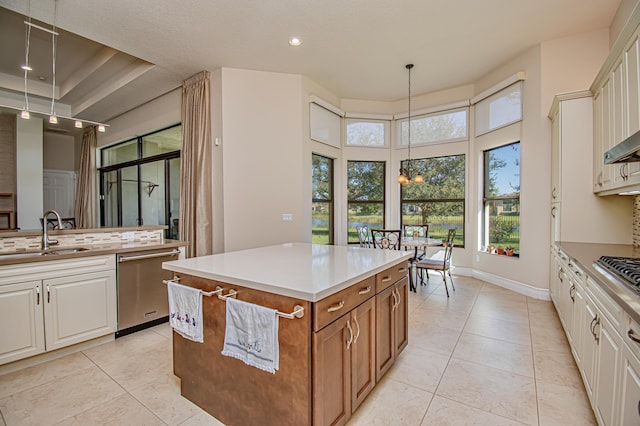 kitchen featuring pendant lighting, sink, light tile patterned floors, appliances with stainless steel finishes, and a kitchen island