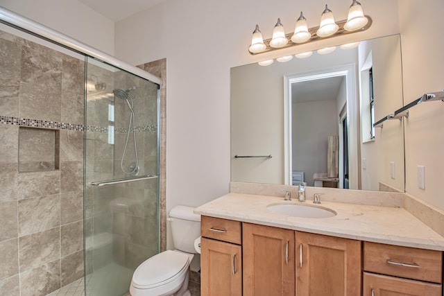 bathroom with vanity, toilet, and a shower with shower door