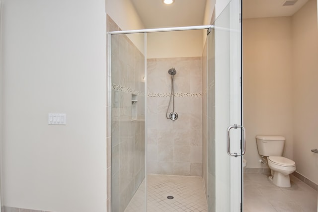 bathroom featuring a shower with shower door, tile patterned floors, and toilet