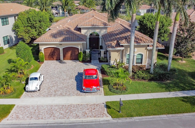 mediterranean / spanish home with a garage and a front lawn