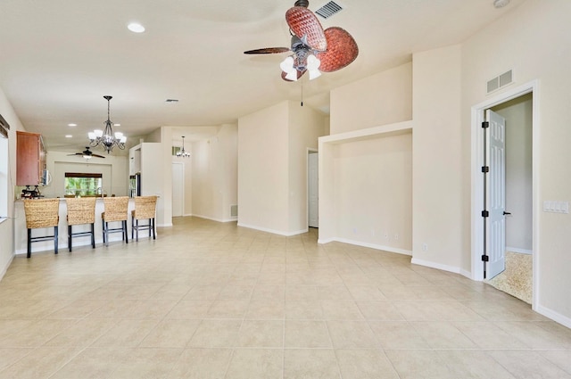 kitchen with light tile patterned floors and ceiling fan with notable chandelier