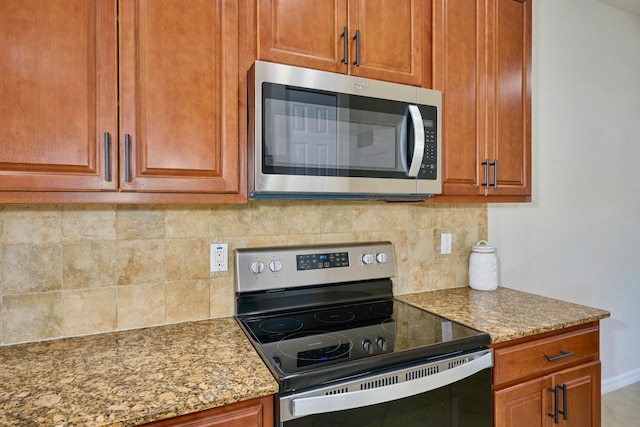 kitchen with light stone countertops, stainless steel appliances, and tasteful backsplash