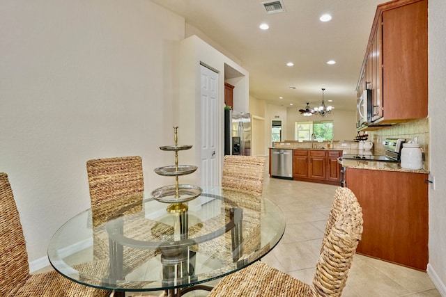 tiled dining room with sink and a notable chandelier