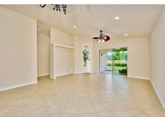 tiled spare room featuring ceiling fan with notable chandelier and lofted ceiling