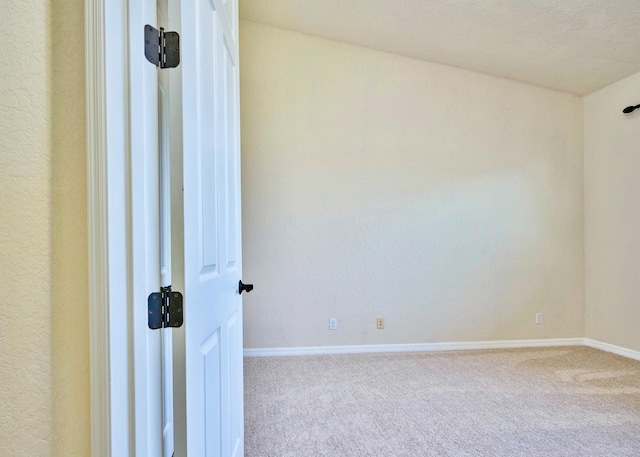 unfurnished room featuring carpet and a textured ceiling