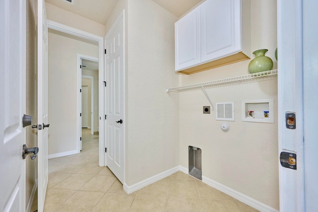 laundry room with electric dryer hookup, hookup for a washing machine, light tile patterned floors, and cabinets