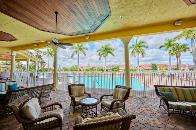 view of patio with outdoor lounge area, ceiling fan, and a community pool