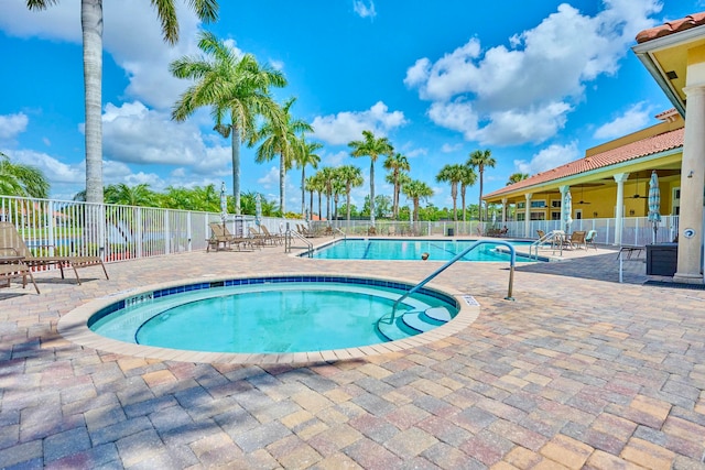 view of swimming pool with a patio area, ceiling fan, and a community hot tub