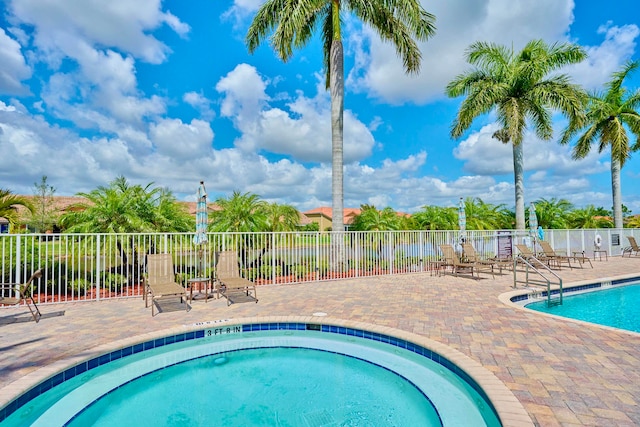 view of pool with a patio area and a hot tub