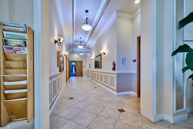 corridor featuring light tile patterned floors and ornamental molding