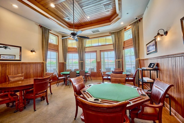 recreation room with a raised ceiling, wood walls, wood ceiling, and light carpet