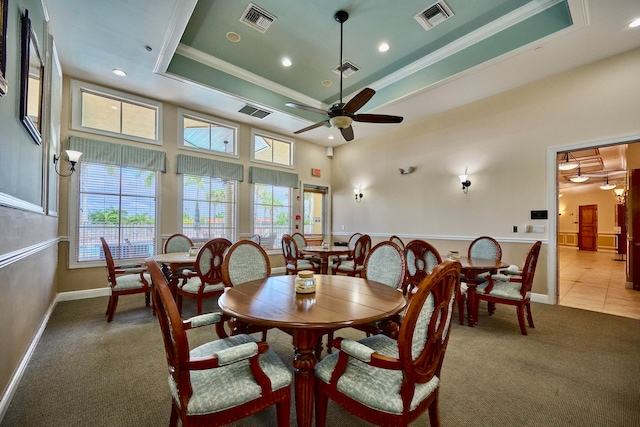 dining area featuring a tray ceiling, ceiling fan, and plenty of natural light