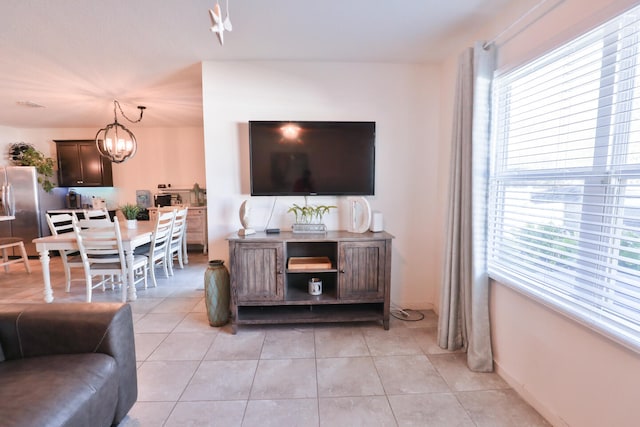 living room with light tile patterned flooring and an inviting chandelier