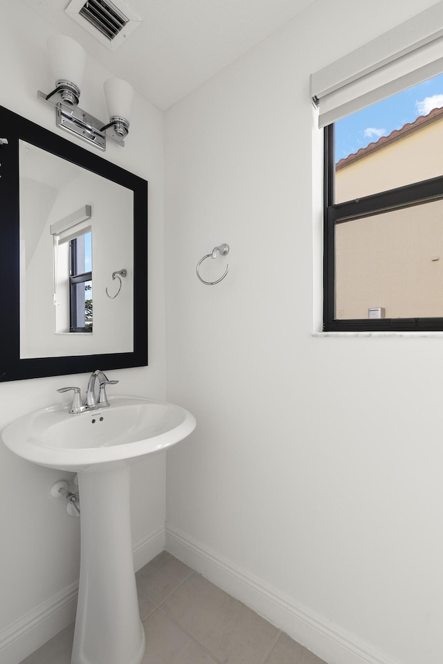 bathroom with tile patterned flooring and a healthy amount of sunlight