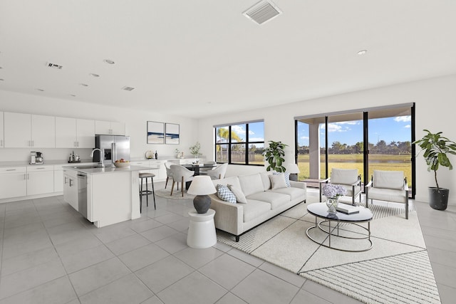 living room featuring sink and light tile patterned floors