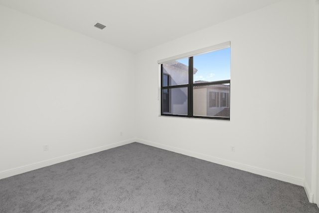 unfurnished room featuring dark colored carpet