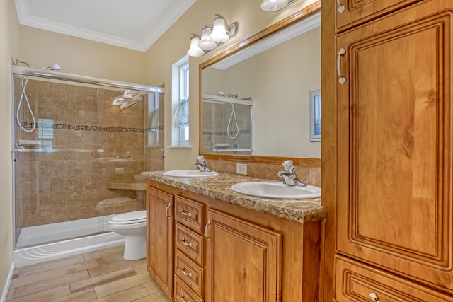 bathroom featuring vanity, toilet, an enclosed shower, and ornamental molding