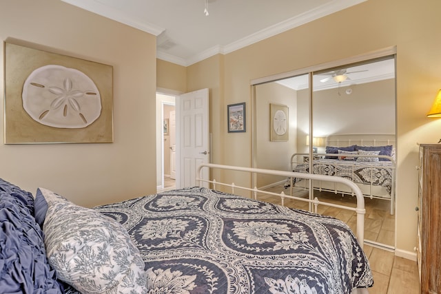 bedroom featuring light wood-type flooring, crown molding, and a closet