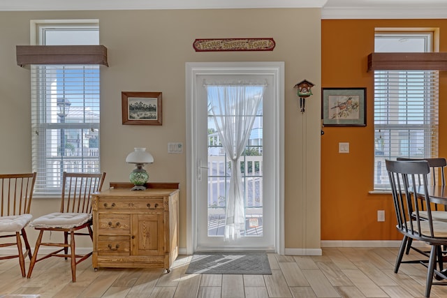 entryway with light hardwood / wood-style floors and ornamental molding